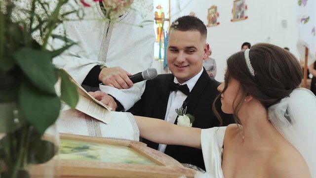 Couple are exchanging vows on their wedding day. Couple of newlyweds in church at the altar