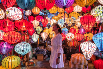 Travel woman choosing lanterns in Hoi An, Vietnam - obrazy, fototapety, plakaty