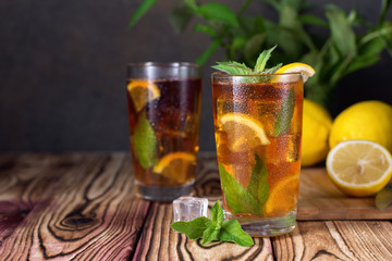 Glass of iced tea with mint and lemon. Cold drink. Rustic style