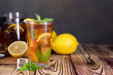 Glass of iced tea with mint and lemon. Cold drink. Rustic style