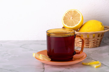 Glass of tea with mint and lemon on marble table.