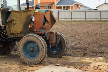 old rusty weathered tractor in a yard