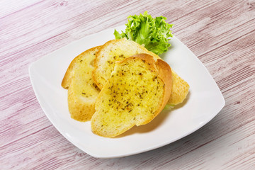 Garlic bread on white plate