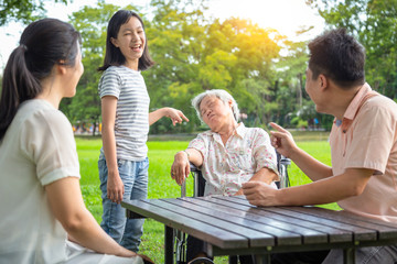 Asian father,mother,child girl or daughter funny,laugh in family,while senior grandmother sit asleep,snooze,elderly woman resting falling asleep,feel doze,sleepy in the park, exhaustion,sleep concept