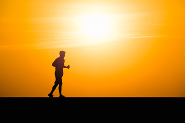 Silhouette man running on sunset background