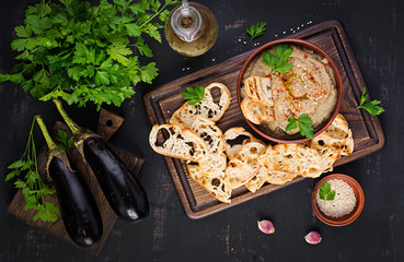 Baba ghanoush vegan hummus from eggplant with seasoning, parsley and toasts. Baba ganoush. Middle...