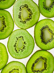 Fototapeta premium Close-up slices of kiwi on light white backgroun