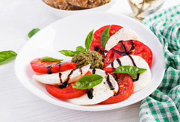 Traditional Italian Caprese Salad with mozzarella, tomato, basil and balsamic vinegar