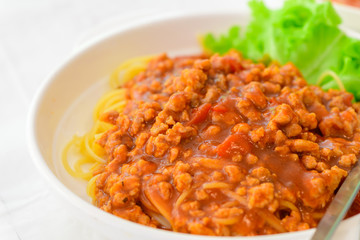 Spaghetti with pork sauce on white table,