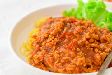 Spaghetti with pork sauce on white table,