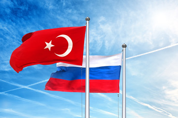 turkish and russia national flag waving against cloud blue sky side view of natural color of republic of turkey and russian federation state symbols isolated for design copy space template mockup