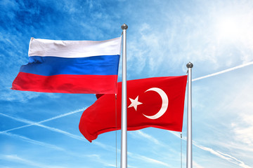 russia and turkish national flag waving against cloud blue sky side view of natural color of russian federation and republic of turkey state symbols isolated for design copy space template mockup