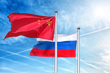 china and russia national flag waving against clouds blue sky side view of natural color of people republic of china and russian federation state symbols isolated for design mockup copy space template