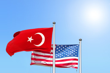 turkish and usa national flag waving against sunny blue sky side view of natural color republic of...