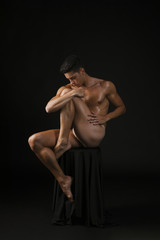 Fototapeta na wymiar Naked guy embracing knee