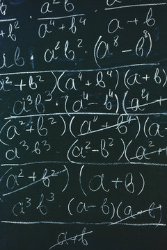 Maths formulas written by white chalk on the chalkboard background.