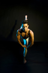 Fototapeta na wymiar Professional male ballet performer dancing in spotlight