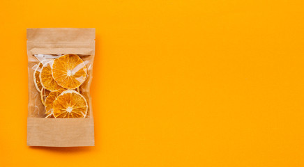 Homemade fruit chips - orange slices, dried in the oven , in a package of Kraft paper. Place for text