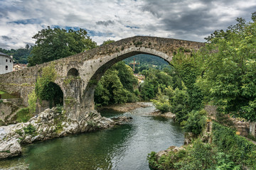 Fototapeta na wymiar The Roman bridge of Cangas de Onís is a construction located on the Sella River as it passes through Cangas de Onís (Asturias, Spain)