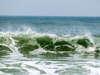 landscape with waves ashore with horizon and gray sky