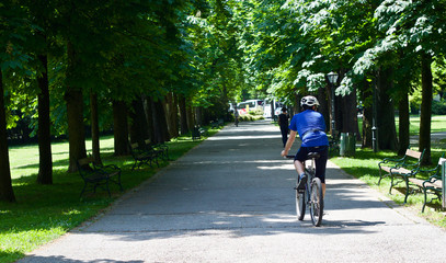 Ein junger Radfahrer fährt durch einen schönen Park
