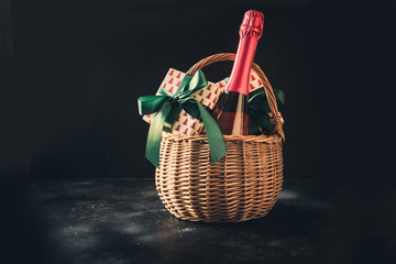 Christmas gift hamper with champagne and gift on black. Space for your greetings. greeting card
