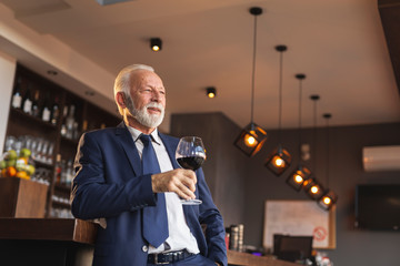 Senior businessman drinking wine