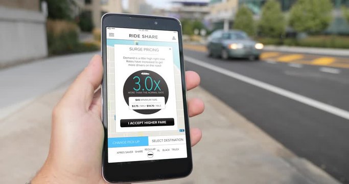 A man holds a smartphone showing a ridesharing app. A popup denotes current 3x surge pricing.  	