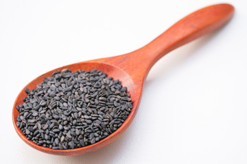 Black sesame seeds in the wooden spoon. Sesame seeds 