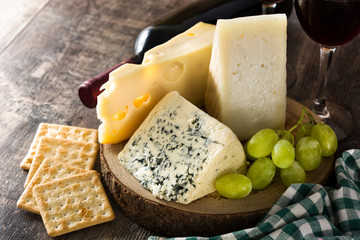 Assortment of cheeses and wine on wooden table