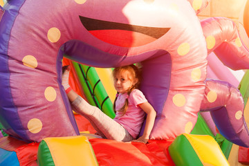 A cheerful child plays in an inflatable castle