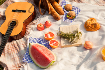 Lunch in the park on the green grass. Summer sunny day and picnic basket