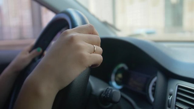 Close up of Asian woman's hand driving car
