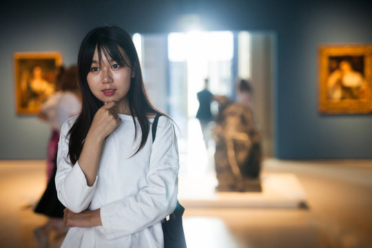 Chinese young woman near picture collection in the museum