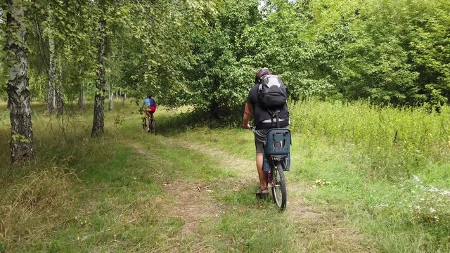 Kiev, Ukraine, Europe - August 2019: Bike ride on a forest road. A cyclist rides on a road in the forest. Bike tour through the woods.