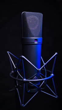 studio condenser microphone, isolated on black. with blue light