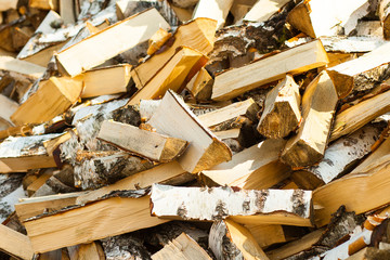 A pile of split birch firewood. Woodpile of chopped birch wood.