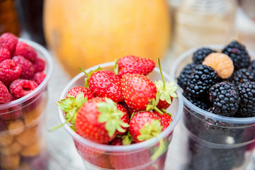 Fresh berries in plastic glasses for sale in market