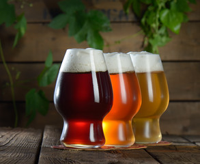 Different beer in glasses on wooden background