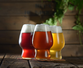 Different beer in glasses on wooden background