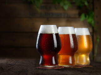 Different beer in glasses on wooden background