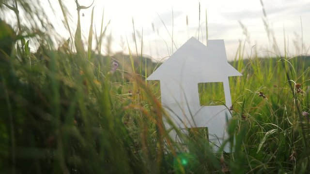 building happy family construction house concept lifestyle . paper house stands in the green grass in nature. symbol life ecology video