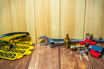 Plumbing repair supplies and tools on wooden, antique background.