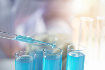 Researcher with glass laboratory chemical test tubes with liquid for analytical , medical, pharmaceutical and scientific research concept.