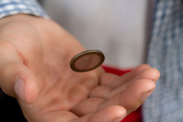 close up shot of hand toss a coin, probable and winning chances concept, fifty-fifty