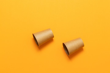 Paper cups in a chaotic position on an orange background with space for text. Minimal flat lay