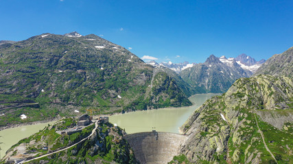 Obraz na płótnie Canvas Dam at the glacier lakes in the Swiss Alps - aerial view