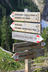 Signpost for excursions, red and white hiking trail sign in Dolomites, Italy