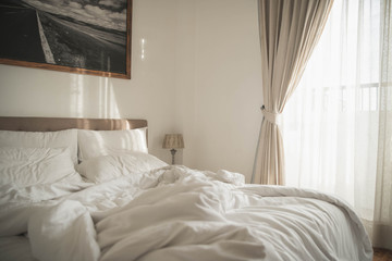 White interior of cozy bedroom with  morning light. Cozy bedroom beside window and sunlight in the...