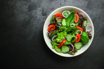 Healthy salad, leaves mix salad (mix micro greens, cucumber, tomato, onion, other ingredients). food background. copy space